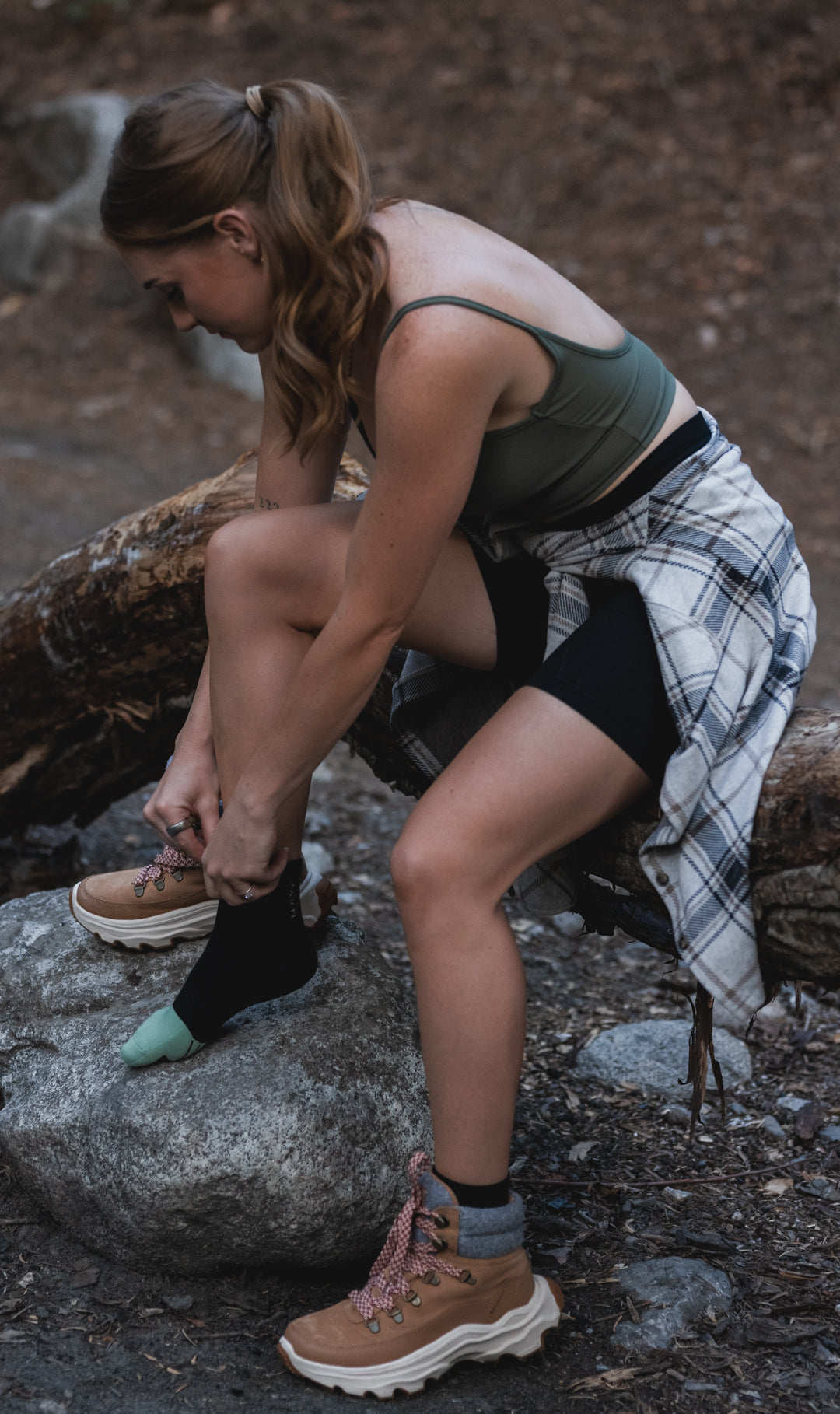 Woman tying her hiking boots in a natural setting